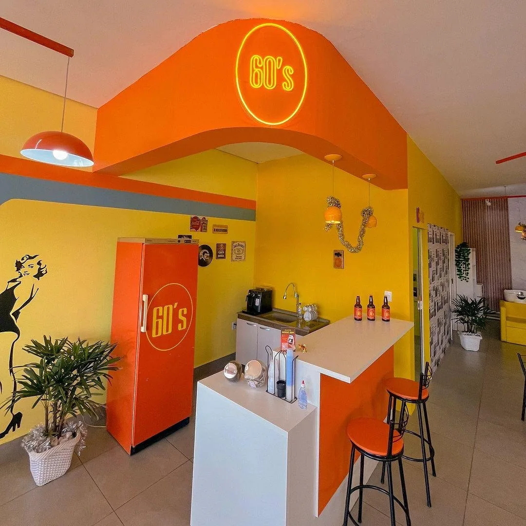 Bar interno e arco iluminado com o logo 60's